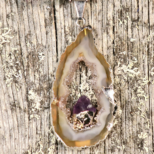 Riipus akaattisiivu, jonka keskellä ametistikide nro AKAM29