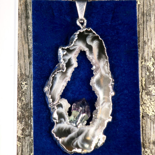 Riipus akaattisiivu, jonka keskellä ametistikide nro AKAM28