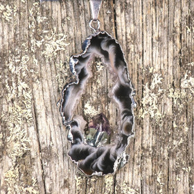 Riipus akaattisiivu, jonka keskellä ametistikide nro AKAM28