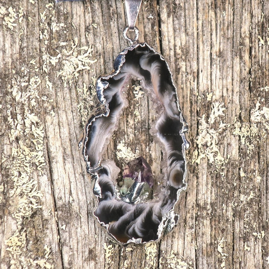 Riipus akaattisiivu, jonka keskellä ametistikide nro AKAM28