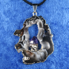 Riipus akaattisiivu, jonka keskellä ametistikide nro AKAM92