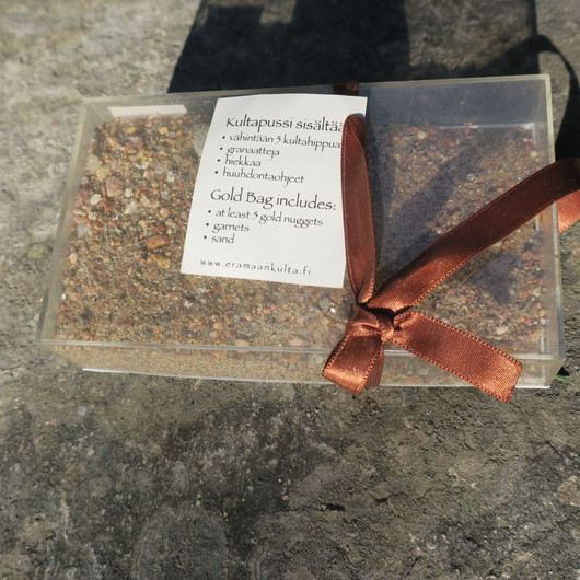 Hiekkaa, kultahippuja ja granaatteja kangaspussissa. Lemmenjoki Suomi