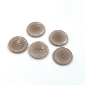 Beige muovinappi helmiäisreunalla