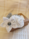 Koristeellinen hiusdonitsi, valkoisella kukkakoristeella