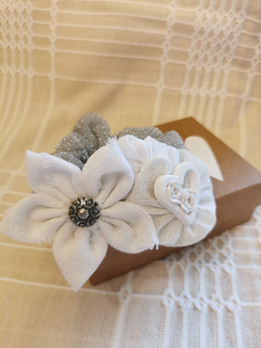 Koristeellinen hiusdonitsi, valkoisella kukkakoristeella