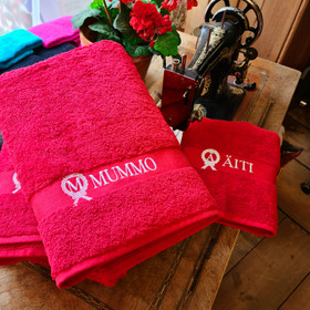 Nimikoitu kylpypyyhe – oma nimi ja alkukirjain kranssissa.