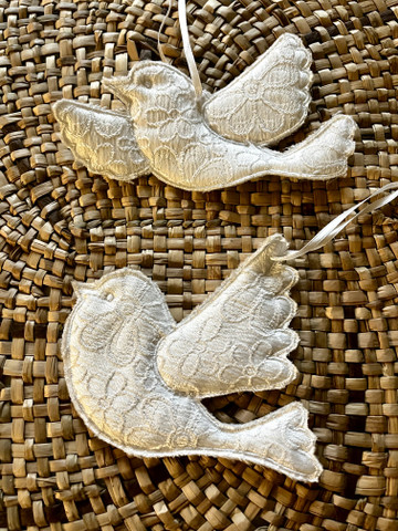 Valkoinen kangaslintu satiininauhassa, kaksi erilaista