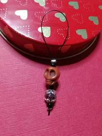 Silmukkamerkki ruskea kallo lenkillä