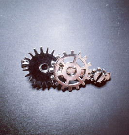 Silver-colored steampunk tie clip with gears.