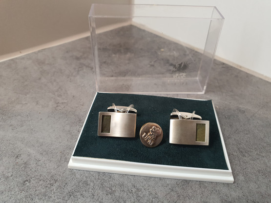 Hopeiset kalvosinnapit ja hopeinen UPM -pinssi