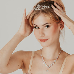 A woman wearing old-fashioned dance jewelry. On her head, she has a sparkling tiara.