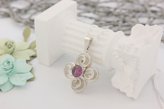 Hopeinen riipus pinkillä kivellä