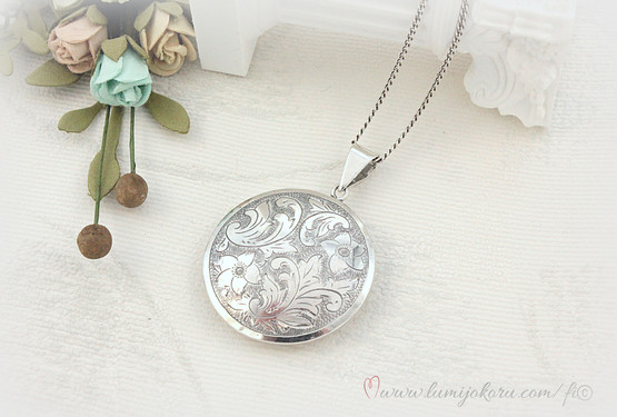 Hopeinen pyöreä riipus pitkässä ketjussa