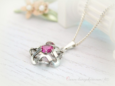 Hopeinen riipus pinkillä kivellä