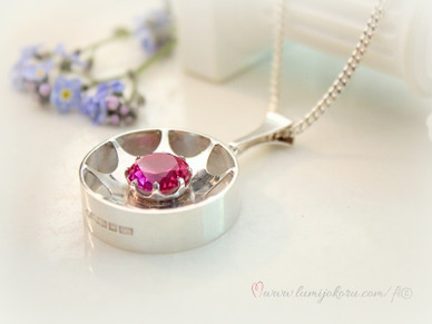 Hopeinen riipus pinkillä kivellä