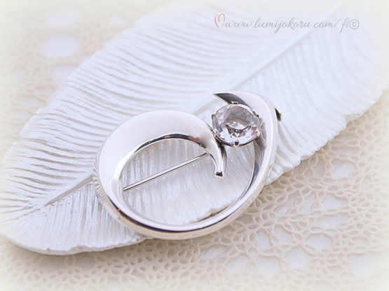 Rintakoru kirkkaalla kivellä hopeaa