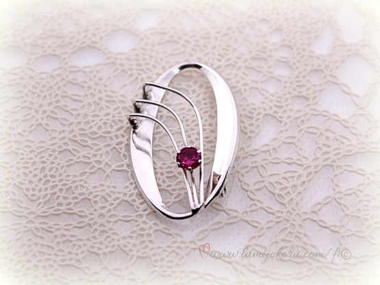 Rintakoru punaisella kivellä hopeaa