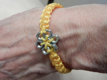 Keltainen ranneke mutterikoristein