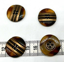 Ruskea nappi jossa metallikoriste