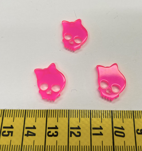 Nappi: Pääkallo jolla rusetti, hohtaa pimeässä